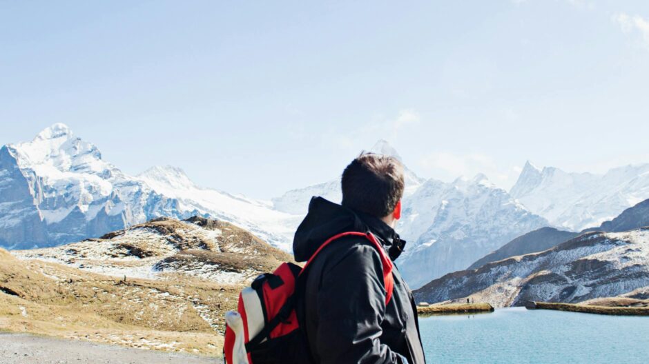 man in black jacket standing near body of water